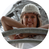 Junge Frau mit Helm lehnt an einer Brüstung