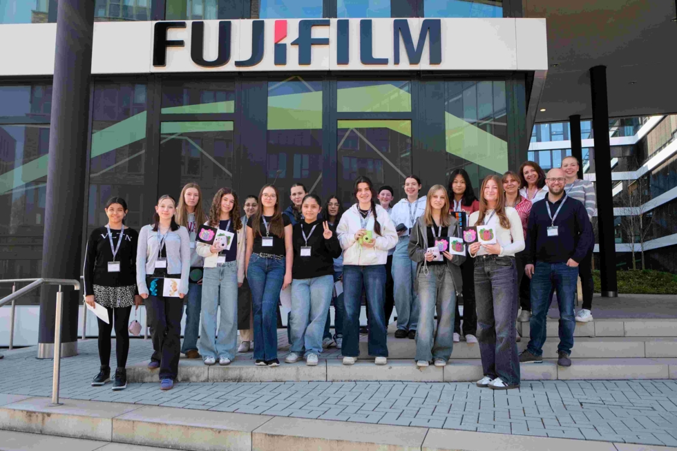 Girls' Day-Teilnehmerinnen und Mitarbeiter vor dem Fujifilm-Gebäude, alle tragen Namensschilder