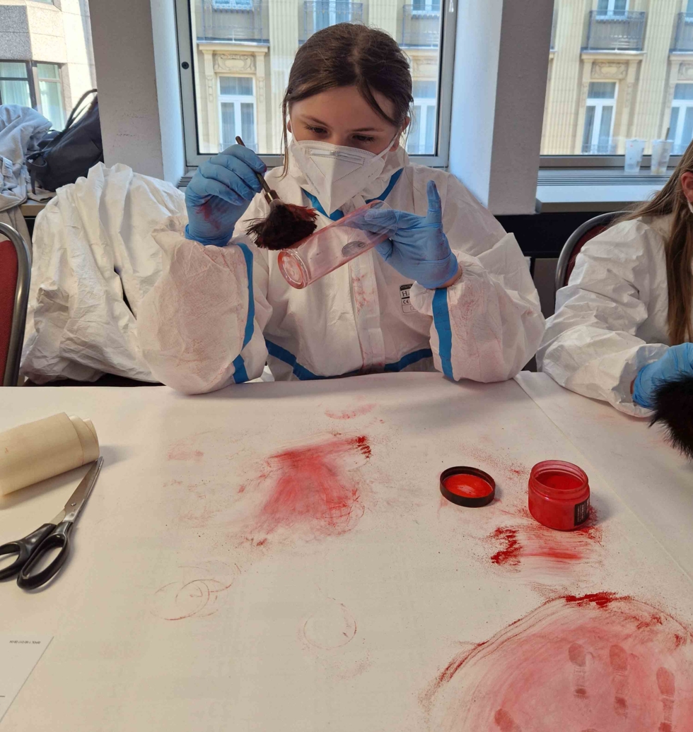 Mädchen in Schutzkleidung experimentiert mit Farbpulver