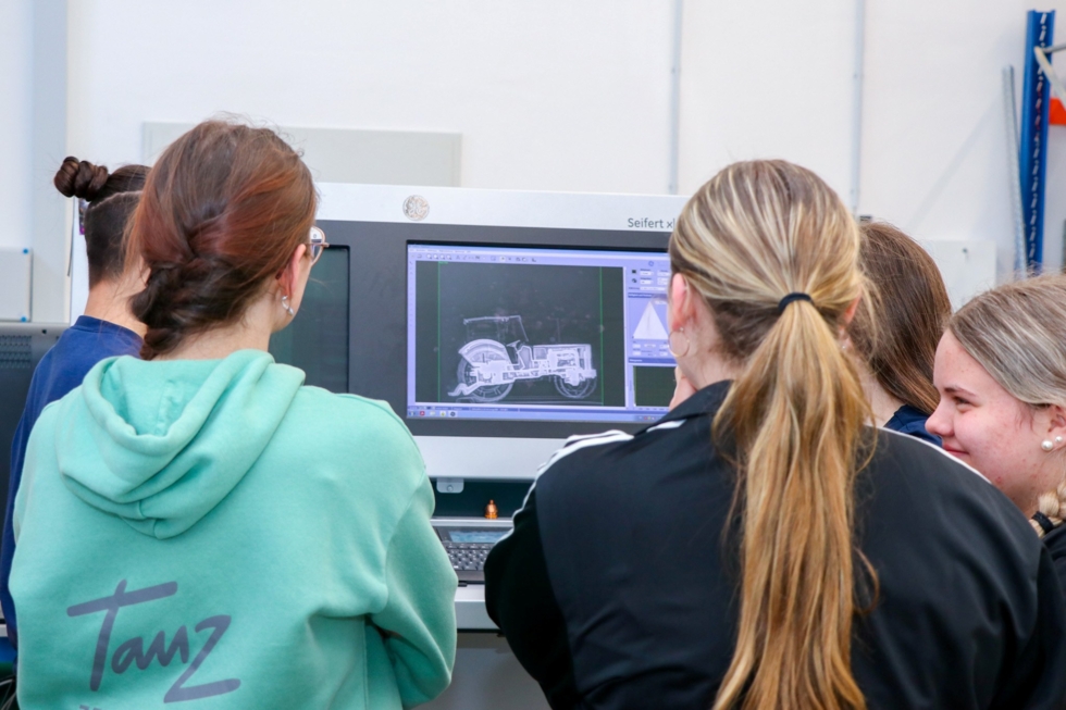 Girls' Day-Teilnehmerinnen schauen auf einen Bildschirm, auf dem ein technisches 3D-Modell dargestellt ist