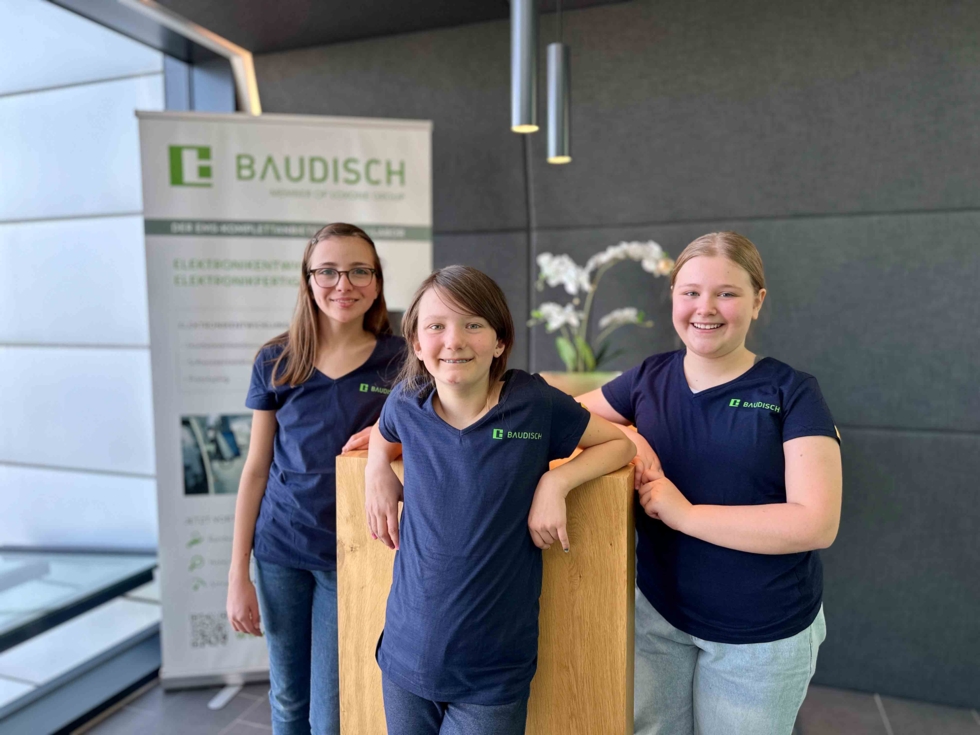 Girls'Day-Teilnehmerinnen vor Firmenbanner