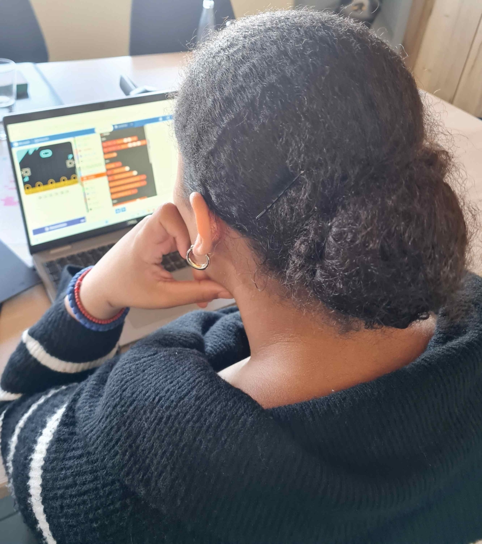 Girl's Day-Teilnehmerin sitzt an einem Laptop und lernt Programmieren