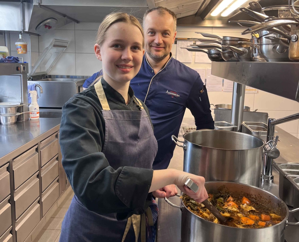 Mädchen mit Mitarbeiter am Suppekochen