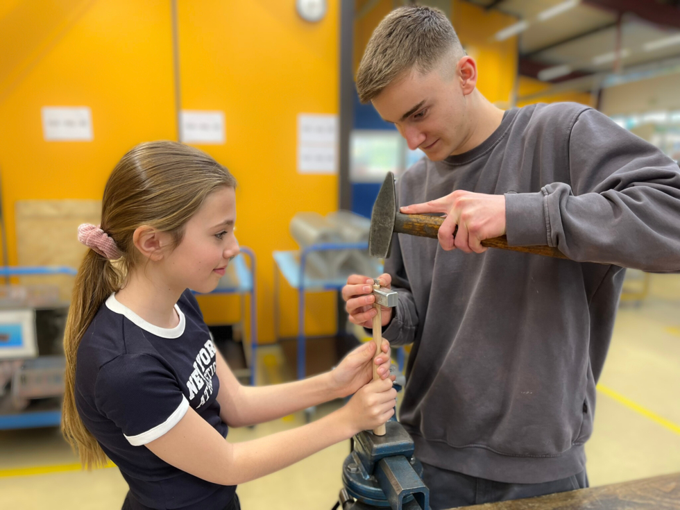 Girls'Day-Teilnehmerin mit Mitarbeiter an Werkbank