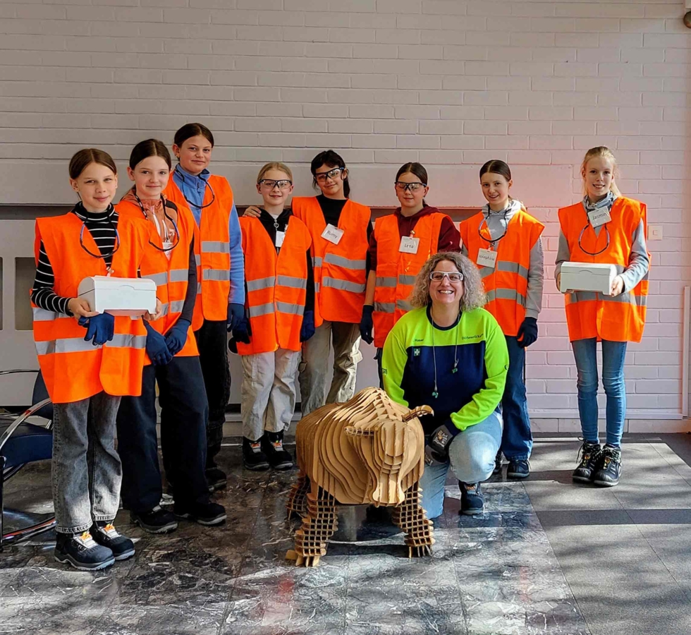 Girls'Day-Teilnehmerinnen mit Mitarbeiterin und Tier aus Pappe