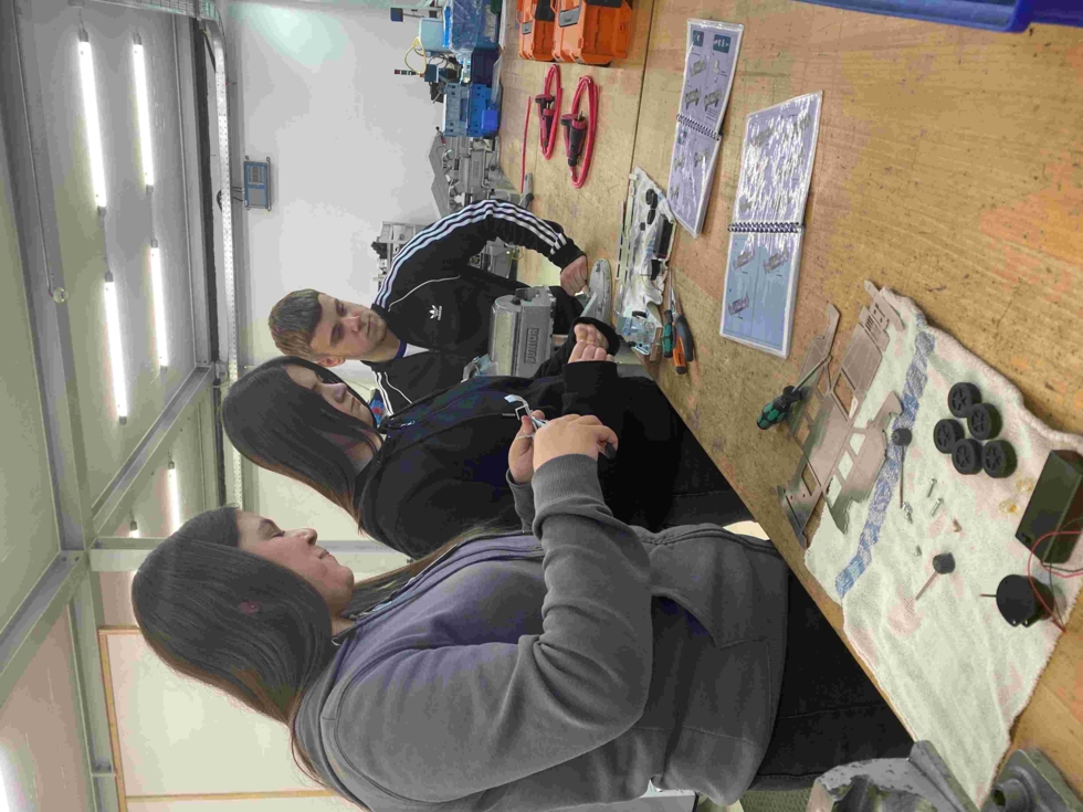 Girls'Day-Teilnehmerinnen mit Konstuktionsplänen in Werkstatt