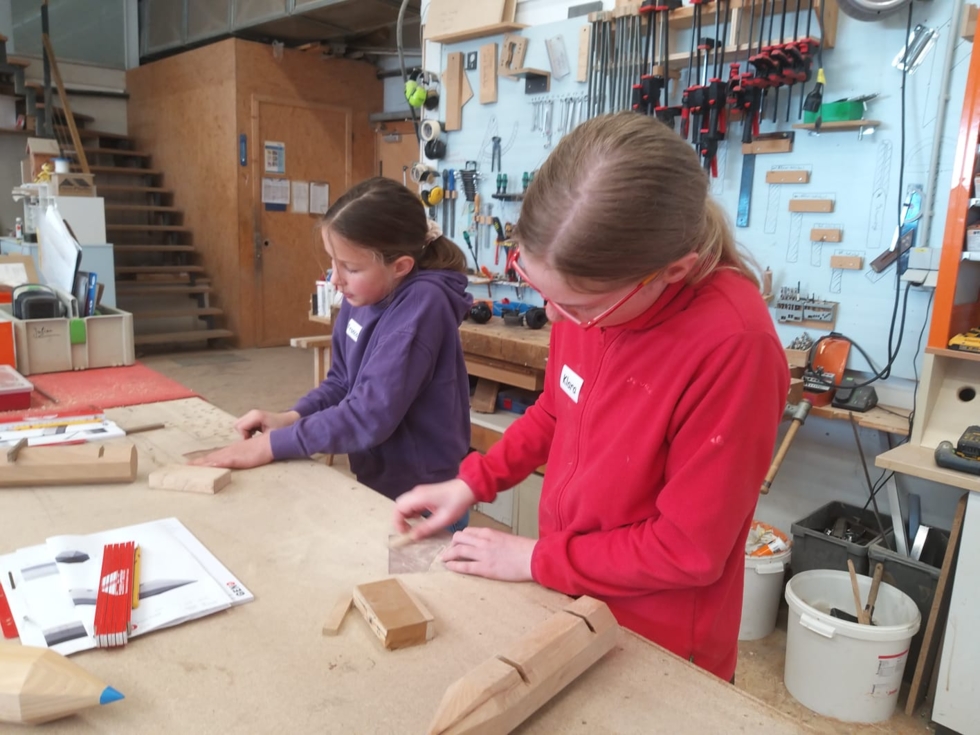 Girls'Day-Teilnehmerinnen in Werkstatt bei Schreinerarbeiten