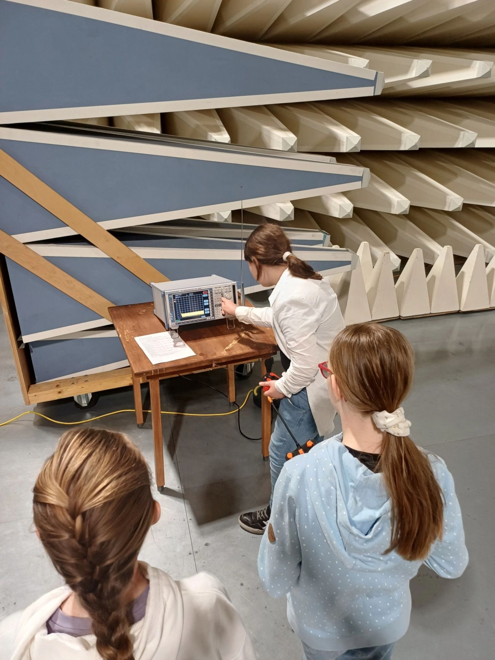 Girls' Day-Teilnehmerinnen beobachten eine Demonstration mit einem Messgerät in einem technischen Umfeld